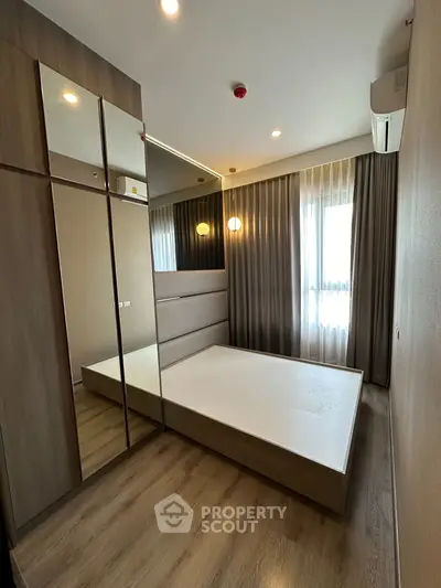 Modern bedroom with mirrored wardrobe and large window
