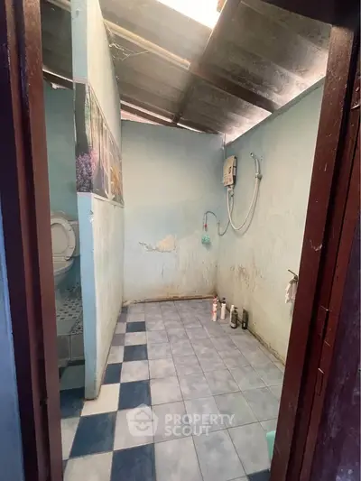 Basic bathroom with tiled floor and shower, minimalistic design.