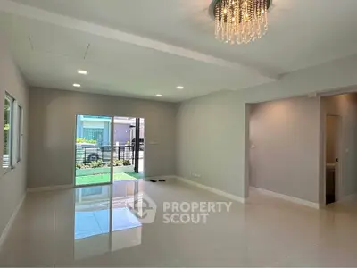 Spacious modern living room with elegant chandelier and large windows