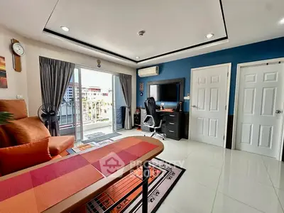 Modern living room with balcony view, stylish furniture, and vibrant decor in a contemporary apartment.