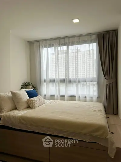 Cozy bedroom with large window and modern decor in urban apartment