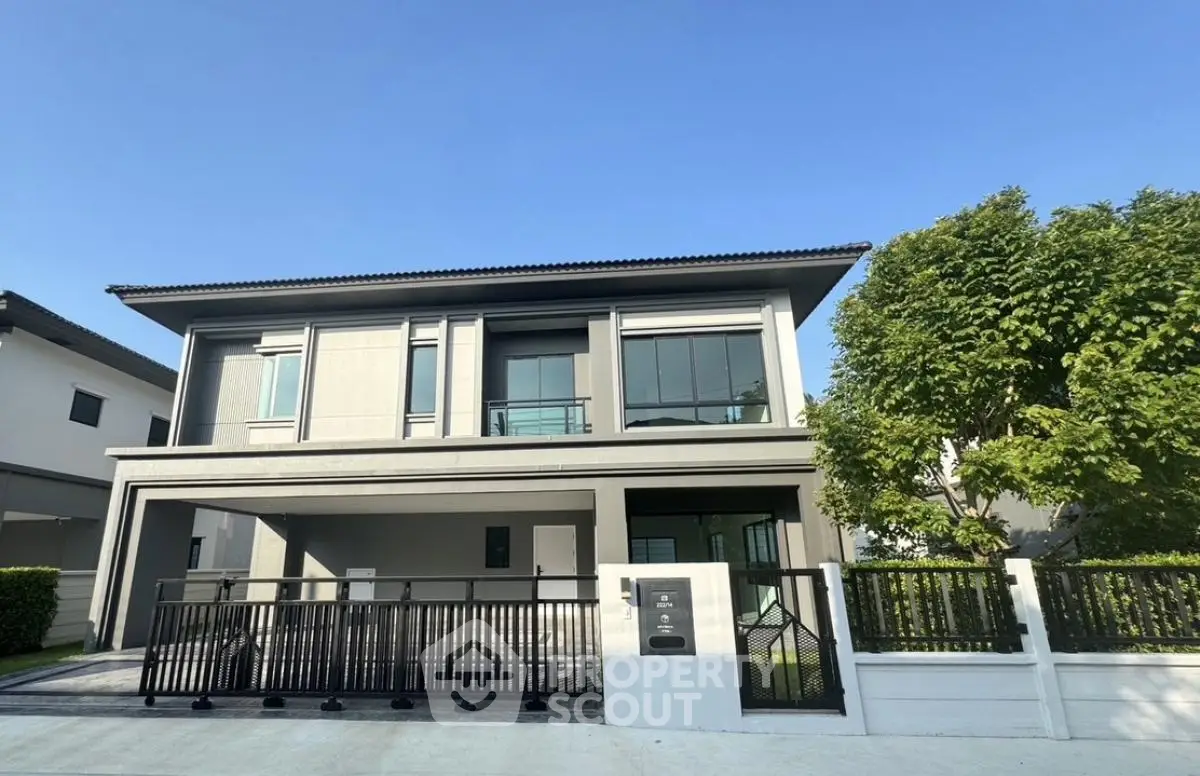 Modern two-story house with sleek design and spacious driveway in a serene neighborhood.