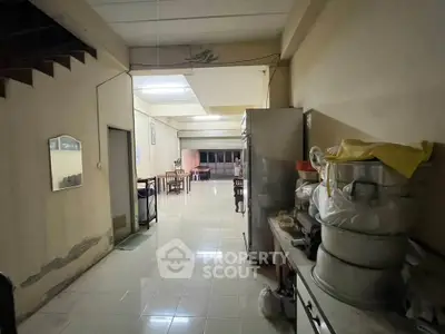 Spacious open-plan kitchen and dining area with tiled flooring and ample natural light.