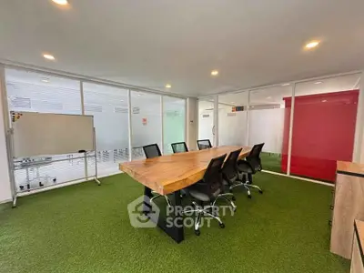 Modern office space with green carpet and wooden conference table