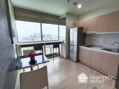 Modern kitchen with city view, sleek cabinets, and dining area in a high-rise apartment.