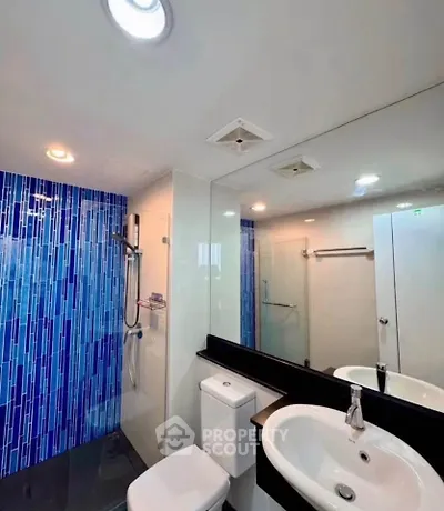 Modern bathroom with blue tile accent wall and sleek fixtures