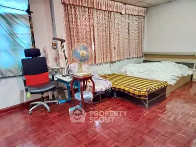 Spacious bedroom with parquet flooring and cozy sleeping arrangements.