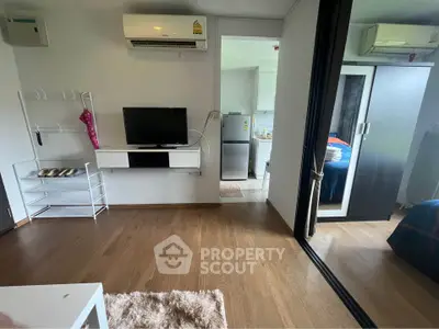 Modern apartment interior with wooden flooring, TV, air conditioning, and stylish decor