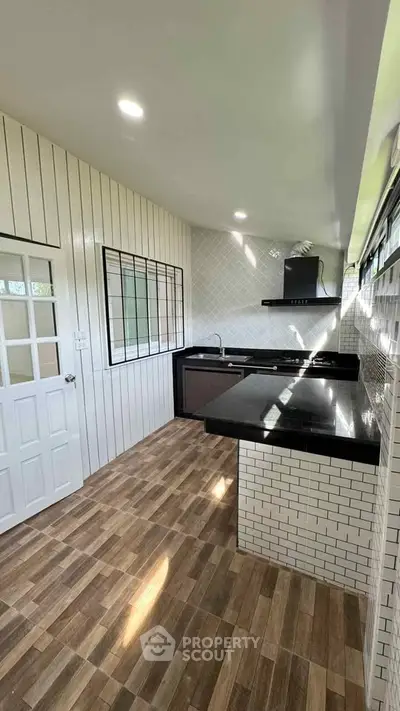 Modern kitchen with sleek black countertops and stylish tile backsplash