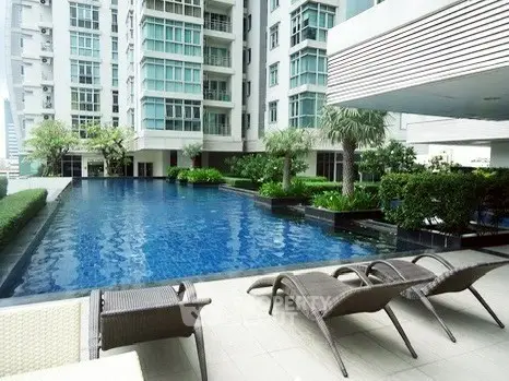 Luxurious condominium with stunning pool and modern architecture in urban setting.