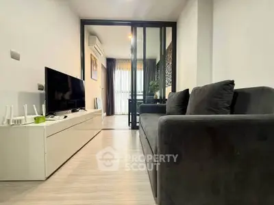 Modern living room with sleek furniture and glass partition in a stylish apartment.