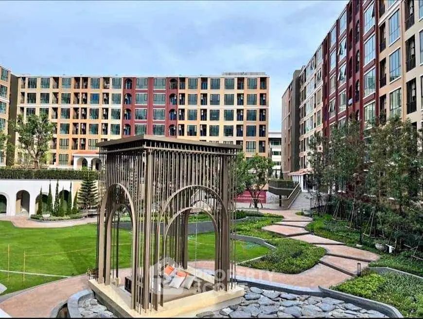 Modern apartment complex with landscaped garden and unique architectural feature