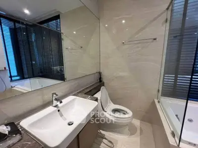 Modern bathroom with sleek fixtures and large mirror in luxury apartment.