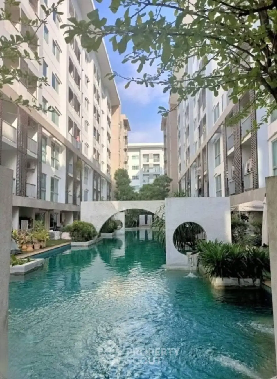 Luxurious apartment complex with stunning pool and modern architecture.