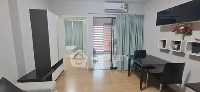 Modern living room with sleek furniture and open layout, featuring a view into a cozy bedroom.