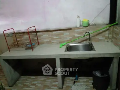 Simple kitchen with concrete countertop and stainless steel sink