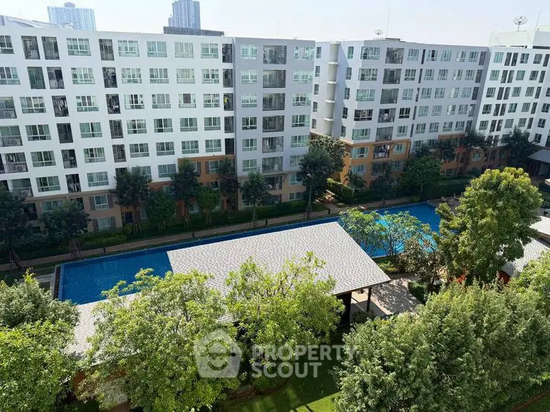 Modern apartment complex with pool and lush greenery, offering a serene urban living experience.