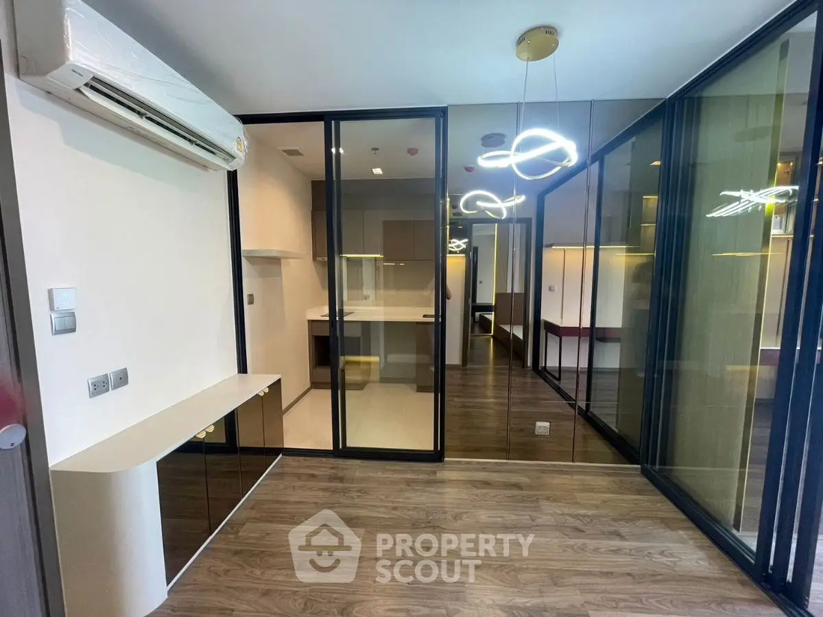 Modern interior with glass partitions and stylish lighting in a compact living space.
