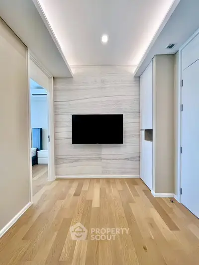 Modern minimalist living room with wooden flooring and wall-mounted TV