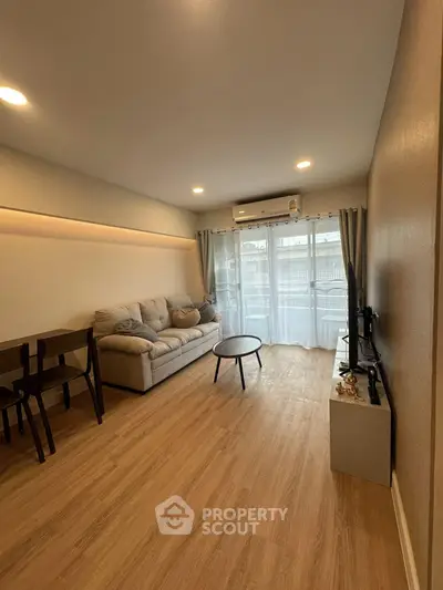 Spacious living room with modern decor and natural light from large windows.