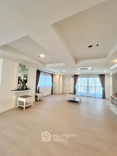 Spacious living room with elegant decor and large windows for natural light