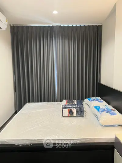 Modern bedroom with sleek curtains and new bedding in a stylish apartment.