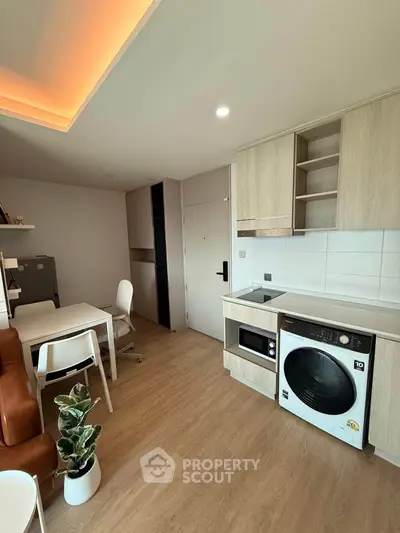 Modern apartment interior with open kitchen and living area, featuring built-in appliances and stylish furniture.