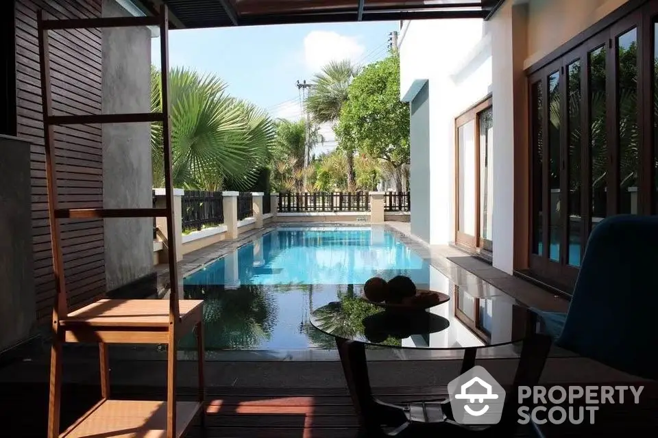 Luxurious private pool view from modern patio with tropical landscaping