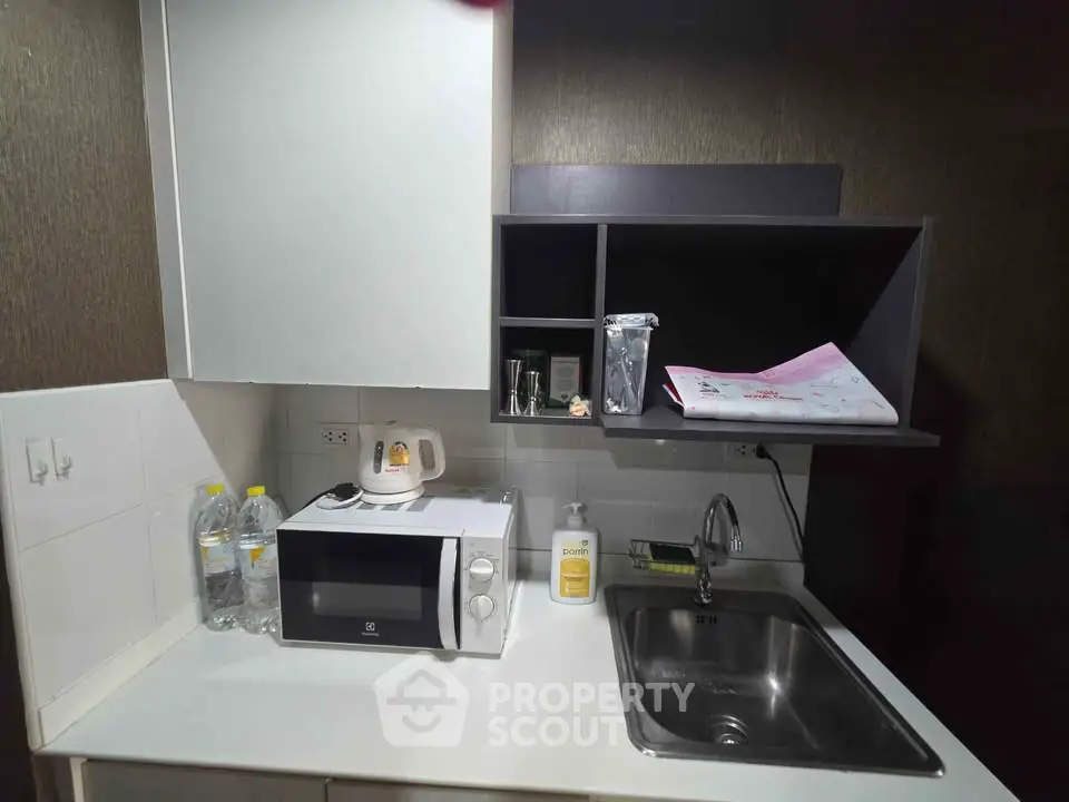 Compact modern kitchen with microwave and sink, ideal for urban living.