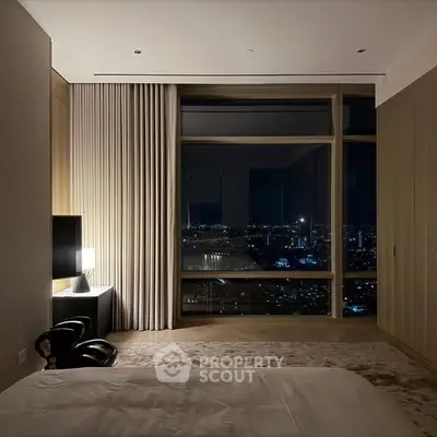 Luxurious bedroom with stunning city night view from floor-to-ceiling windows.