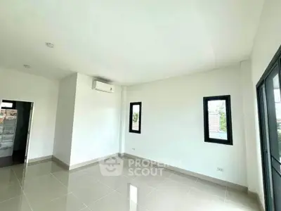 Spacious empty room with large windows and air conditioning, perfect for customization.