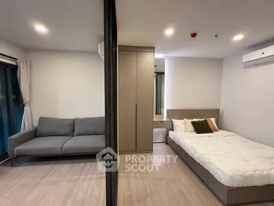 Modern bedroom with cozy sofa and stylish decor in a contemporary apartment.