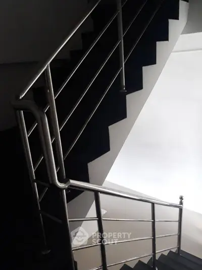 Modern staircase with sleek metal railing in a contemporary building