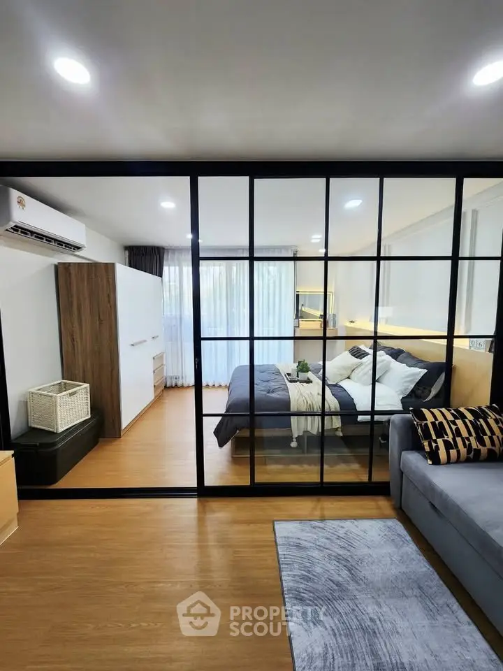 Modern bedroom with glass partition and stylish decor in a contemporary apartment.