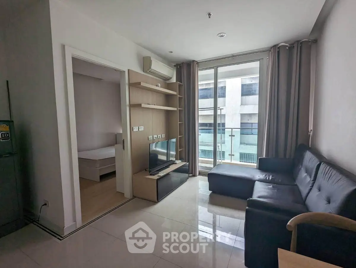 Modern living room with sleek furniture and large windows offering city views, perfect for urban living.