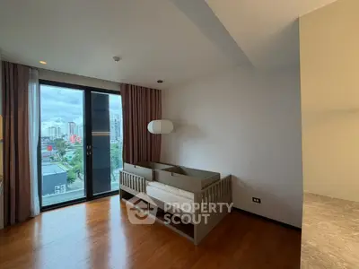 Spacious bedroom with city view and stylish crib, perfect for urban family living.