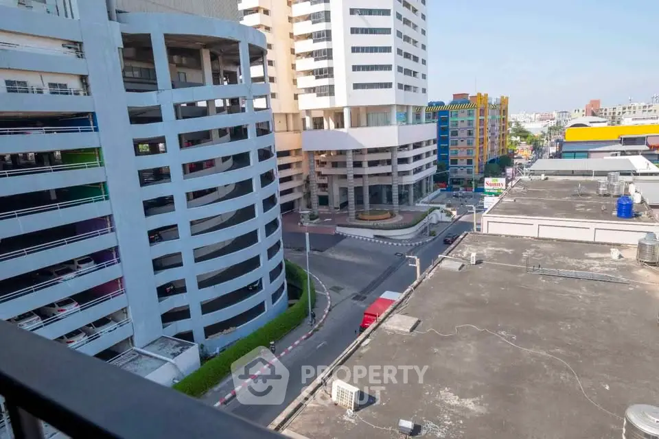 Urban cityscape view from a high-rise balcony showcasing modern architecture and vibrant city life.