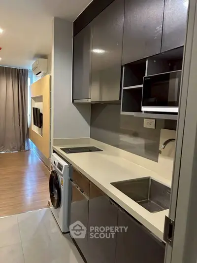 Modern compact kitchen with sleek cabinetry and integrated appliances