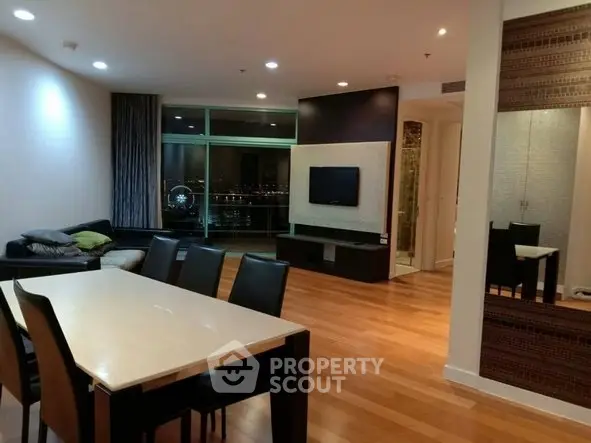 Spacious modern living room with dining area and city view, featuring sleek wooden flooring and contemporary decor.