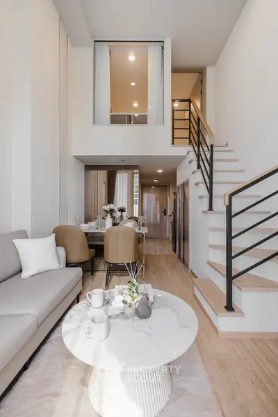 Modern duplex living room with stylish decor and open staircase