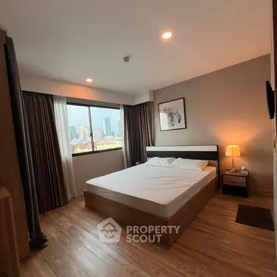 Spacious bedroom with city view, modern decor, and natural light in urban apartment.