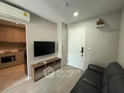 Modern living room with sleek design, featuring a wall-mounted TV and cozy seating area.