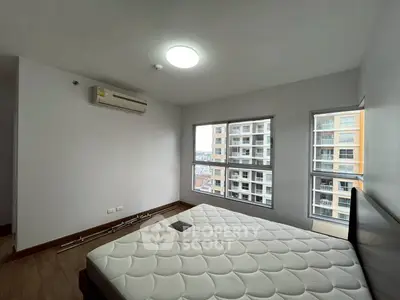 Spacious bedroom with large windows and city view in modern apartment