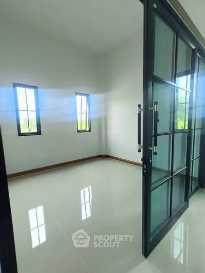 Spacious room with glass doors and large windows offering natural light