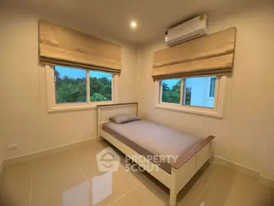Cozy bedroom with single bed, air conditioning, and large windows offering serene views.