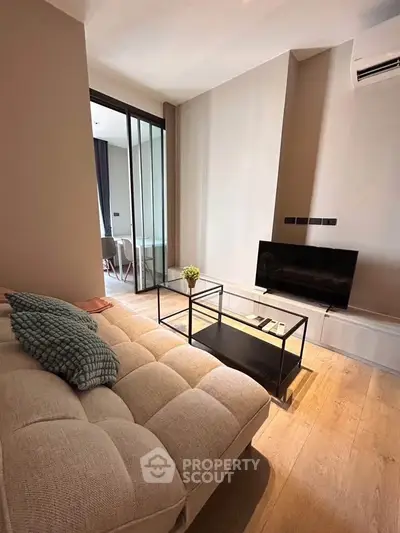 Modern living room with cozy sofa and sleek TV setup in stylish apartment.