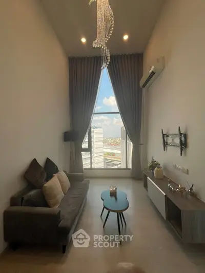 Modern living room with high ceiling and city view, featuring elegant chandelier and minimalist decor.
