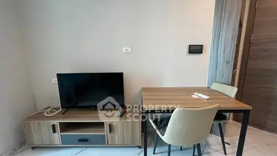 Modern living room with TV and dining table in a cozy apartment setting.