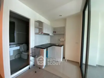 Compact modern kitchen with adjacent bathroom in a cozy apartment