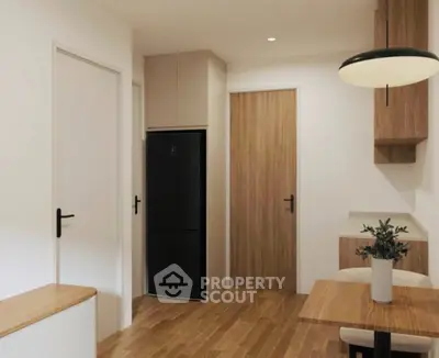 Modern kitchen with sleek design, featuring wooden cabinetry and a black refrigerator.